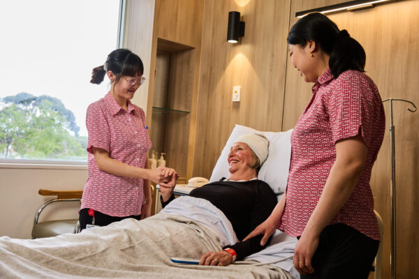 Cabrini nurses with patient in bed